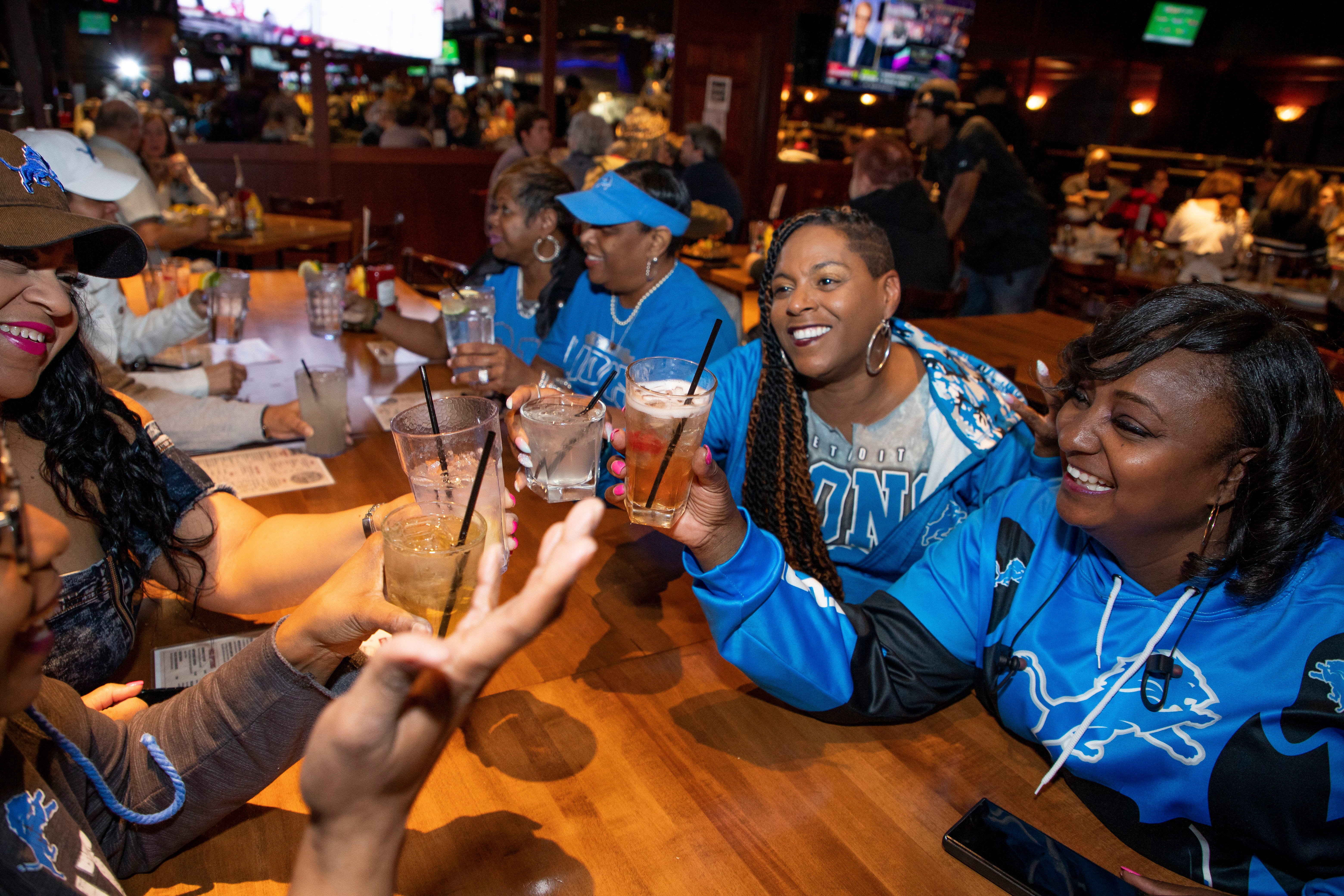 Clockwise from left, Treva Smith, Rasheda Bush, Deshawn Johnson, Tracey Spencer, Jacquelyn Jarrett and Michelle Riggs celebrate with a toast at the beginning of day 2 of the NFL Draft on April 29, 2022, that brought 10 proud members of the Detroit Lions Tailgating Divas to Mr. Joe's Bar and Grill in Southfield. Before the Lions selected Kentucky defensive end Josh Paschal with the team's first pick of Day 2, the Divas celebrated their longtime friendships and even accepted a friendly challenge from another fan to sing the Lions fight song. 