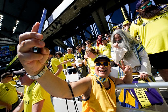 A fan takes a selfie with Nashville SC supporter Stephen Mason, aka Soccer Moses, during the inaugural match at GEODIS Park in Nashville, Tenn., Sunday, May 1, 2022.