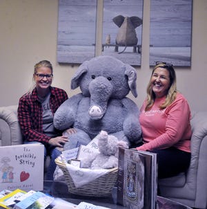 Forget-Me-Not Baskets office manager Mariah Leifheit and President and founder Sara Ringle with the company's large elephant mascot.