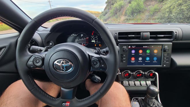 The 6-speed manual, 2022 Toyota GR86 is the better driver's car - but only the automatic (pictured) comes with adaptive cruise control (lower right stalk) and steering wheel-mounted shift paddles.