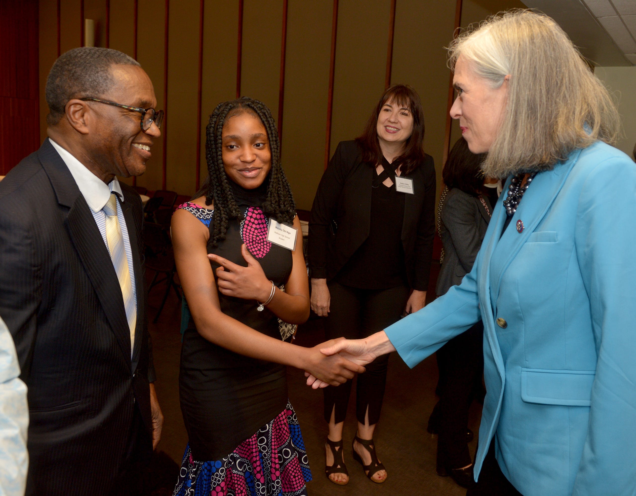 Rep. Katherine Clark, Assistant House Speaker, shakes hands with Melody Obi-Ngo, of Waltham, as her dad, Franklin Ngo, looks on before Clark announced a $600,000 expansion of the MetroWest Scholars Early Start program, early college funding for Waltham students,  at Framingham State University, May 3, 2022.   At center right is Colleen Coffey, executive director of the College Planning Collaborative.