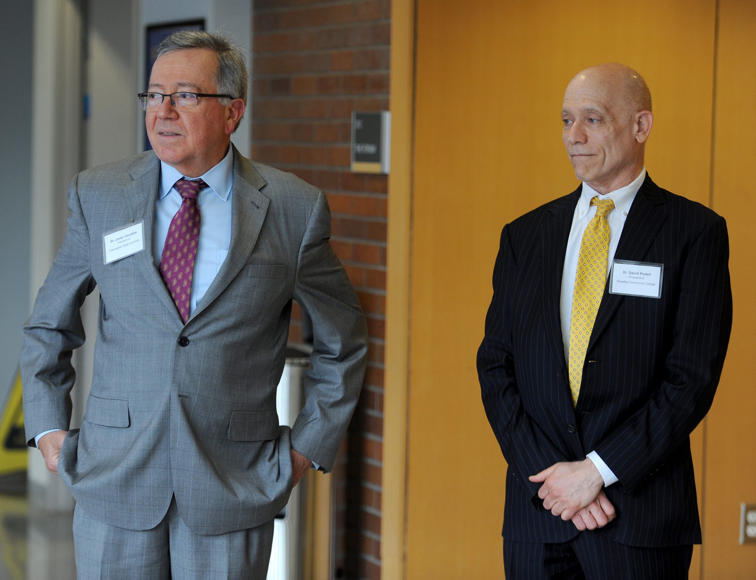 Waiting for Rep. Katherine Clark, Assistant House Speaker, are Framingham State University President Javier Cevallos, left, and Mass Bay Community College President David Podell, May 3, 2022.