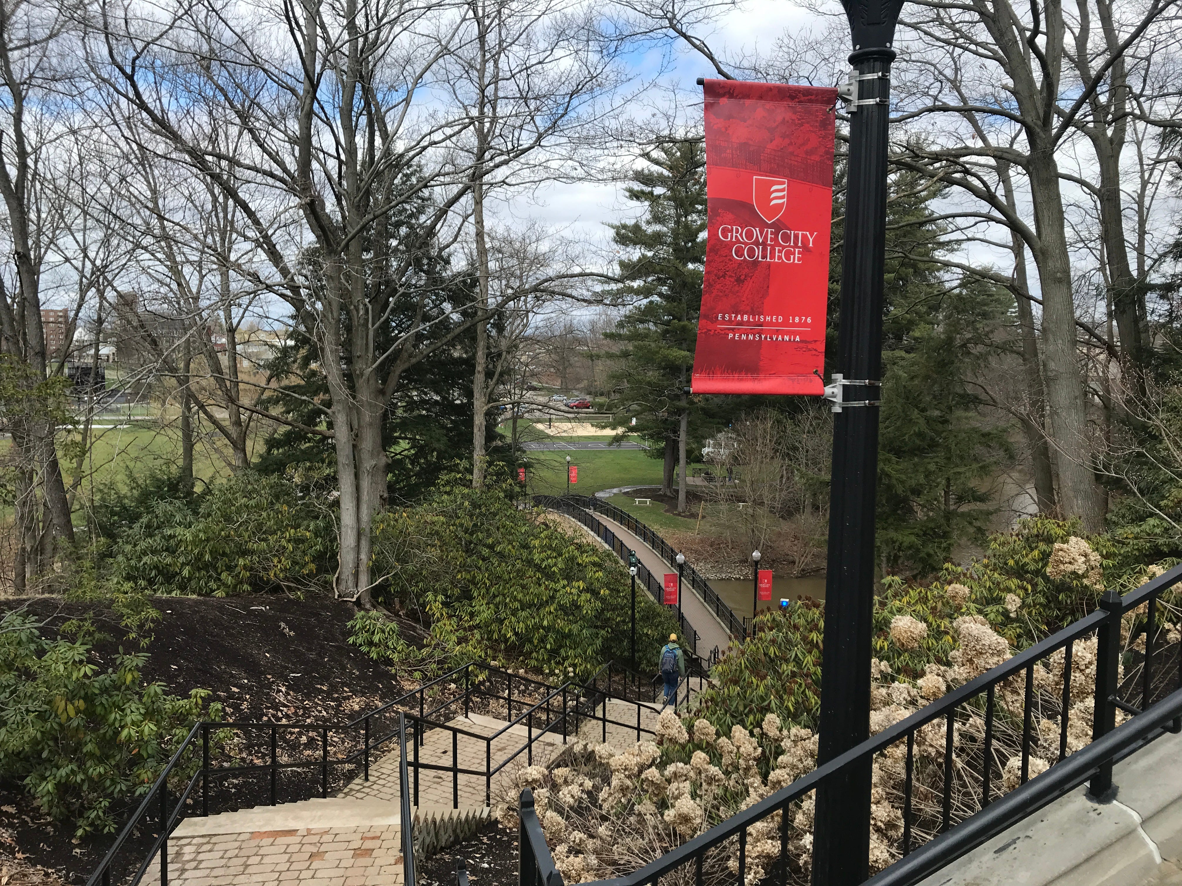 A student walks across Grove City College's campus in early spring 2022