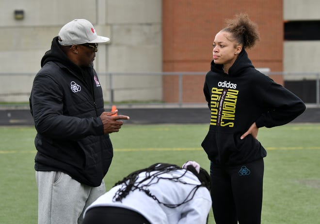 Track coach Darnell Hall, left, talks with senior Leeah Burr, 17, at practice at Renaissance High School.