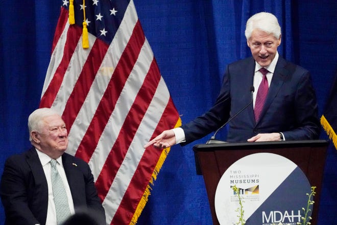 Former President Bill Clinton, right, tells a story about his friend, former Mississippi Republican Gov. Haley Barbour, at the long-delayed memorial service for former Mississippi Gov. William Winter, who died in 2020, and his wife Elise Winter, who died in 2021, Tuesday, May 3, 2022, at the Two Mississippi Museums in Jackson, Miss. President Clinton delivered the keynote remarks. (AP Photo/Rogelio V. Solis)