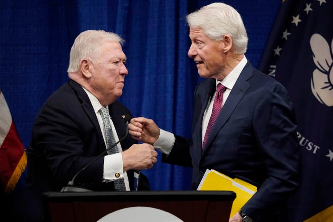 Former President Bill Clinton, right, fist bumps with former Republican Mississippi Gov. Haley Barbour after speaking at the long-delayed memorial service for former Mississippi Gov. William Winter, who died in 2020, and his wife Elise Winter, who died in 2021, Tuesday, May 3, 2022, at the Two Mississippi Museums in Jackson, Miss. (AP Photo/Rogelio V. Solis)