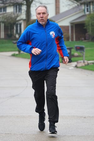                                Mike Webster runs in his Northville Township neighborhood.