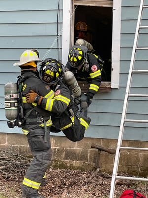 Central Wood County Rapids Intervention Team members practice taking a fallen firefighter out through a window during training Monday evening in Wisconsin Rapids.