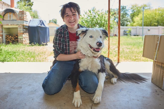Rayne Duncan, 17, poses for a portrait with their dog, Obe, in their family home's backyard in Phoenix on April 30, 2022.