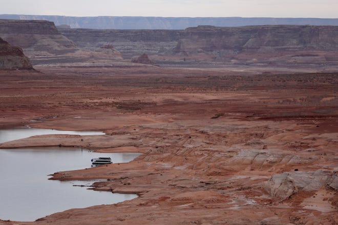 A houseboat sits anchored on the banks of Lake Powell.