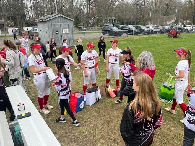Bedford's varsity softball players gather on the field with young softball players from the community before Wednesday's 11-0 win over Adrian.
