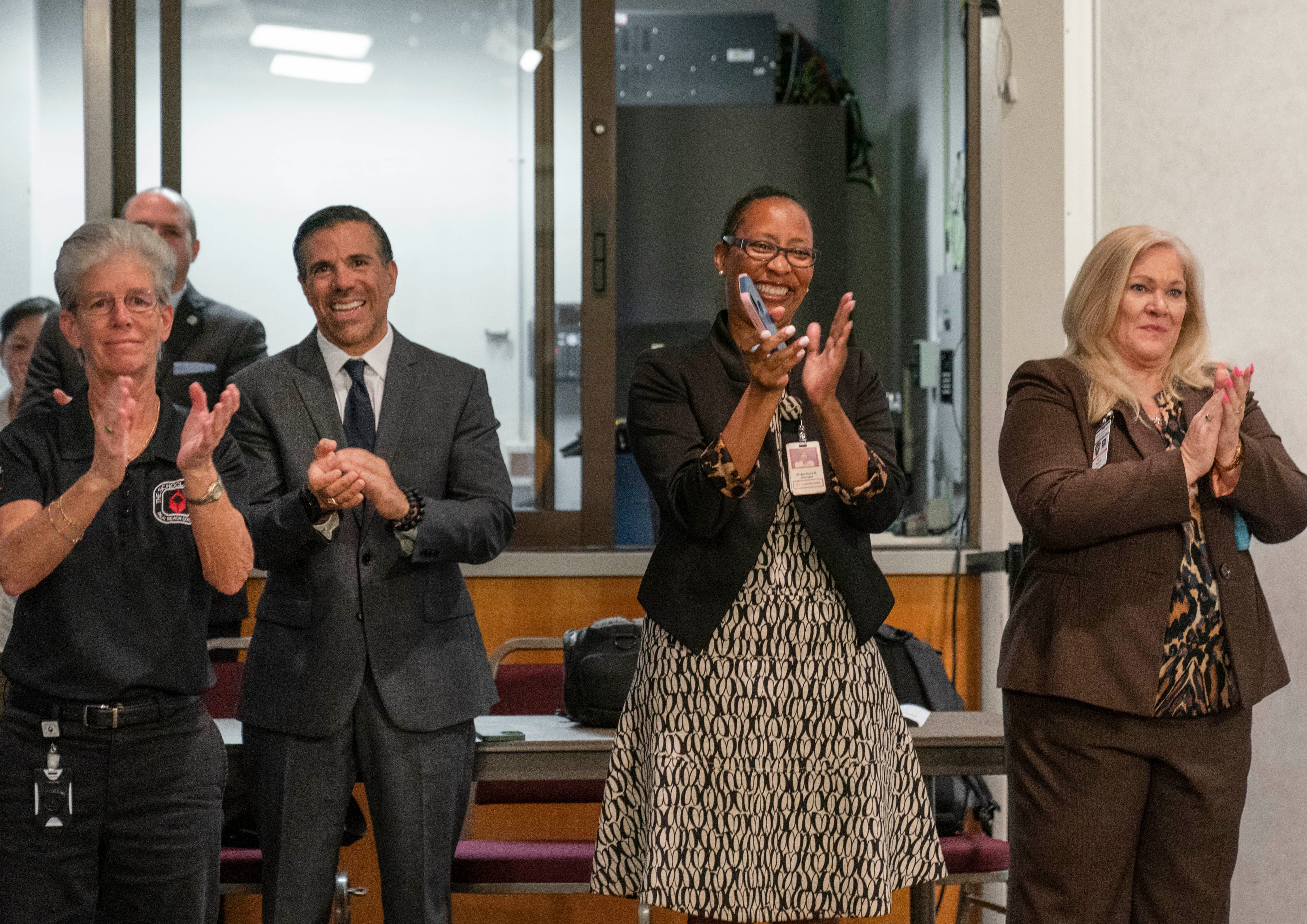 People clap for Sarah Mooney as she is sworn in as the new Chief of the Palm Beach County School Police at a ceremony at district headquarters in West Palm Beach,Florida on May 4, 2021.