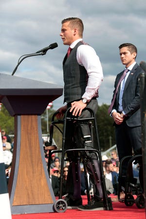 U.S. Rep. Madison Cawthorn, R-N.C., gets up from his wheelchair to speak before former President Donald Trump takes the stage at a rally, Saturday, April 9, 2022, in Selma, N.C.