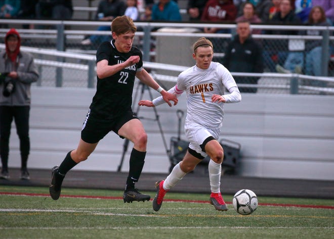 Ankeny Senior Lucas Newhard brings the ball onto the field while Ankeny Centennial Senior Quinn Geiger chases after it during the Pack the Pitch soccer game Tuesday May 3, 2022 in Ankeny.