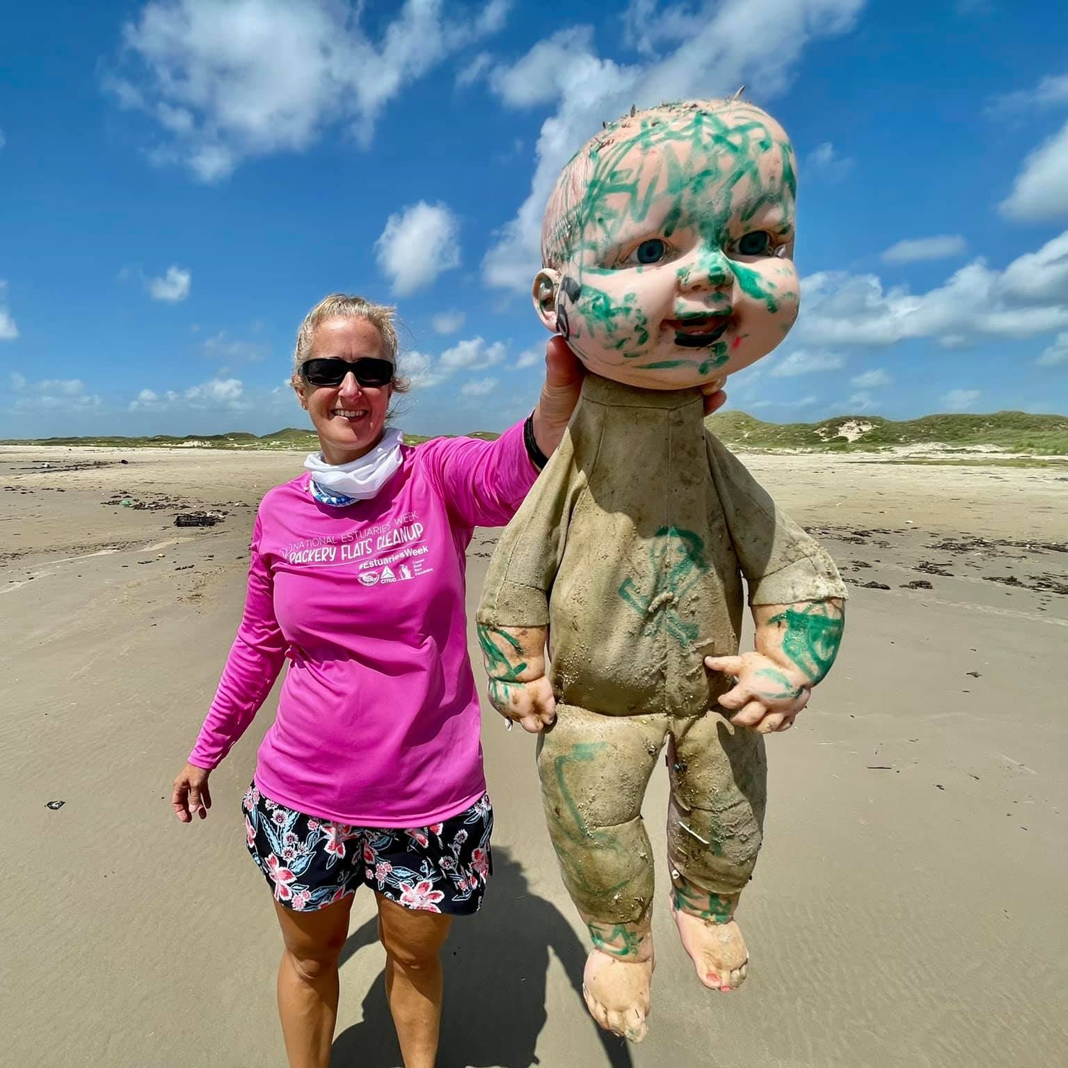 A researcher with Mission-Aransas Reserve at the University of Texas Marine Institute holds a doll found while surveying the coasts from north Padre Island to Matagorda Island in Texas.