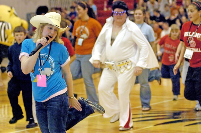The Queen of entertainment at The Classic in the Country, Esther, gets a little help from the King, Elvis in the customary last game line dance at half time. 
