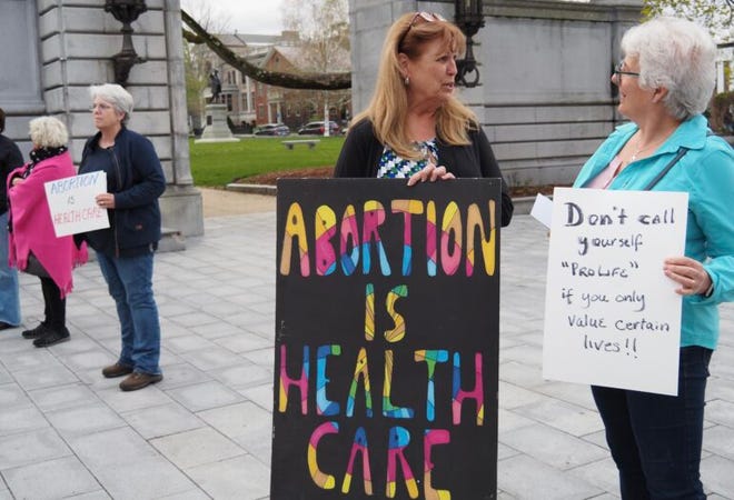 Dalia Vidunas, center, executive director of the Equality Health Center in Concord, and Lisa Spring of Pembroke attend an abortion rights rally at the New Hampshire State House Tuesday.
