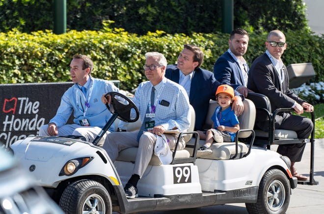 Andrew George, front left, and Honda Classic Executive Director Kenneth Kennerly, front, drive Gov. Ron DeSantis and his son during the second round of the tournament at PGA National in Palm Beach Gardens earlier this year.