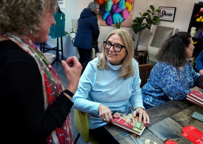 Author Ann Hood, center, signs her new memoir, 