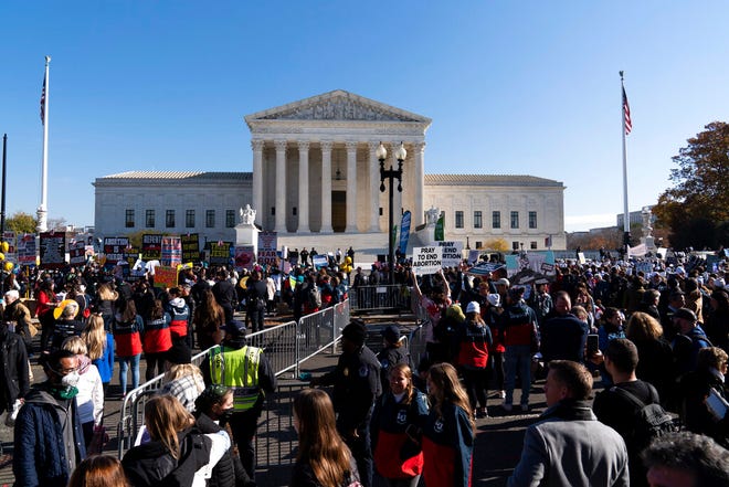 Anti-abortion and abortion rights advocates demonstrate in front of the U.S. Supreme Court Wednesday, Dec. 1, 2021, in Washington, as the court hears arguments in a case from Mississippi, where a 2018 law would ban abortions after 15 weeks of pregnancy, well before viability.