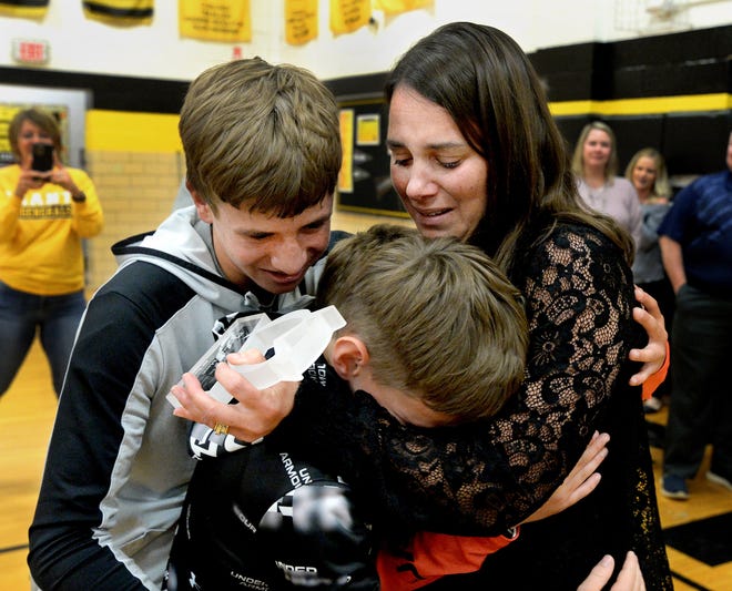 Grant Middle School teacher Jill Borah gets hugs from sons Connor, 11, center, and Clayton 14, on Thursday after she found out she was this year's winner of the Horace Mann Educator of the Year award. [Thomas J. Turney/The State Journal-Register]