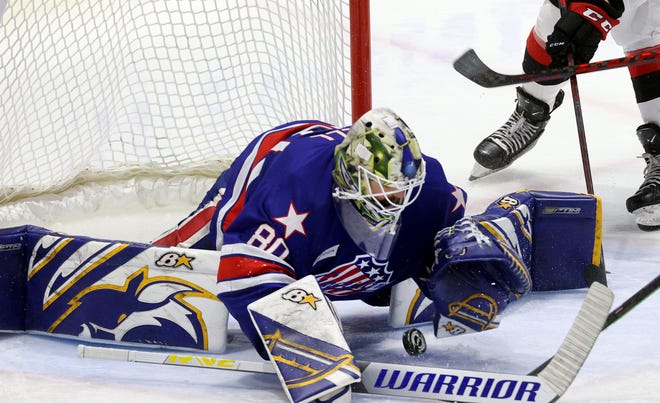 Amerks goalie Aaron Dell tries to control the puck win the crease against Belleville. 