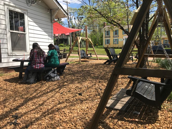 Patrons enjoy coffee in the outdoor space at The Fainting Goat coffee shop on Main Street in Spring Hill in Maury County. An antique shop, used bookstore and historic buildings comprise the short stretch of road in the Old Town district.