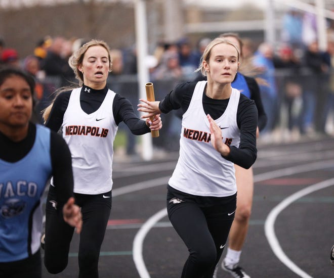 Mediapolis’ Kendal Nollen passes the baton to Kennedy Welliver in the  4x200-meter relay Thursday at WACO.