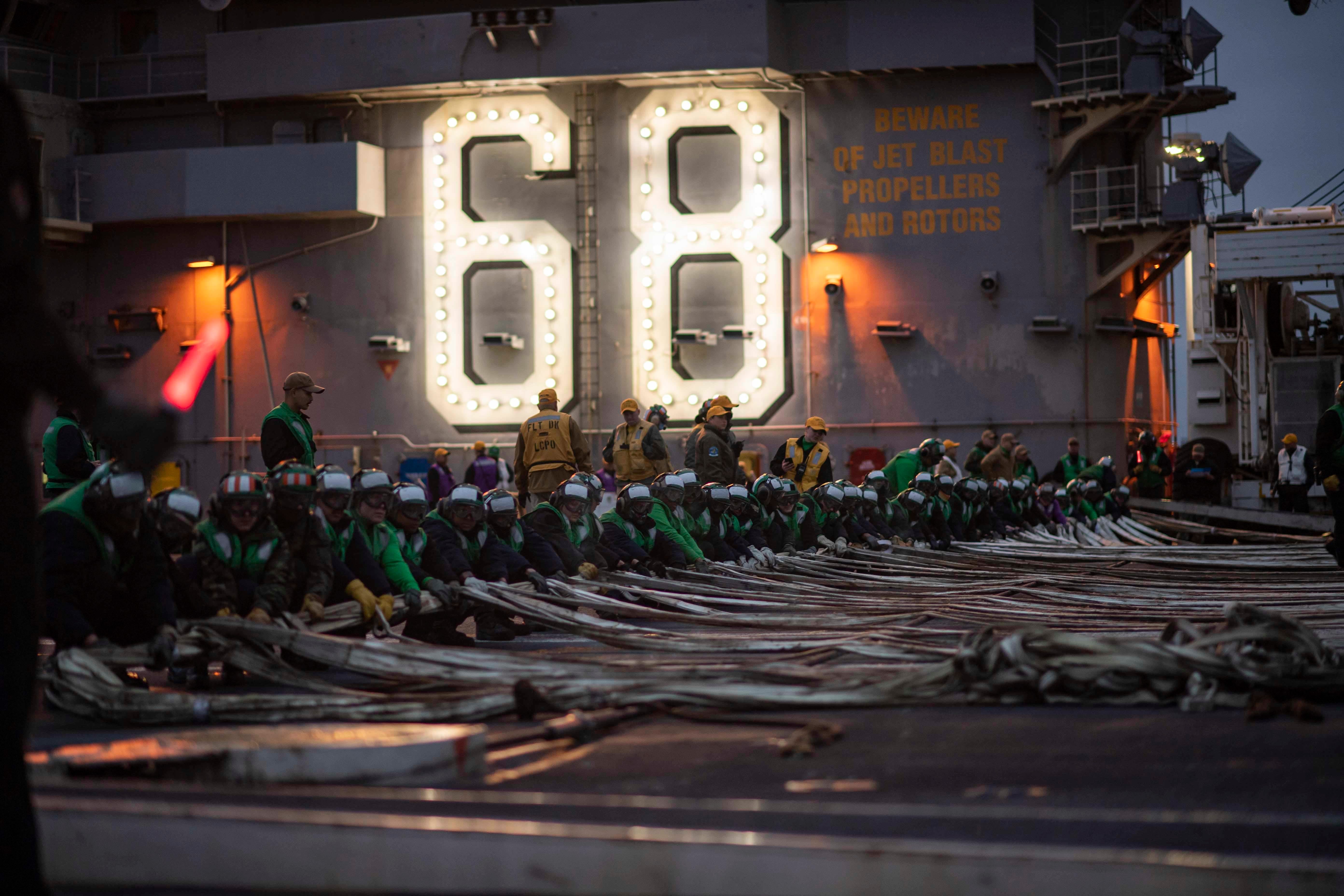 Sailors assigned to the aircraft carrier USS Nimitz conduct drills on the flight deck for what's known as "Tailored Ship's Training Availability/Final Evaluation Problem (TSTA/FEP)" on Tuesday. Nimitz left for the Pacific on Saturday.