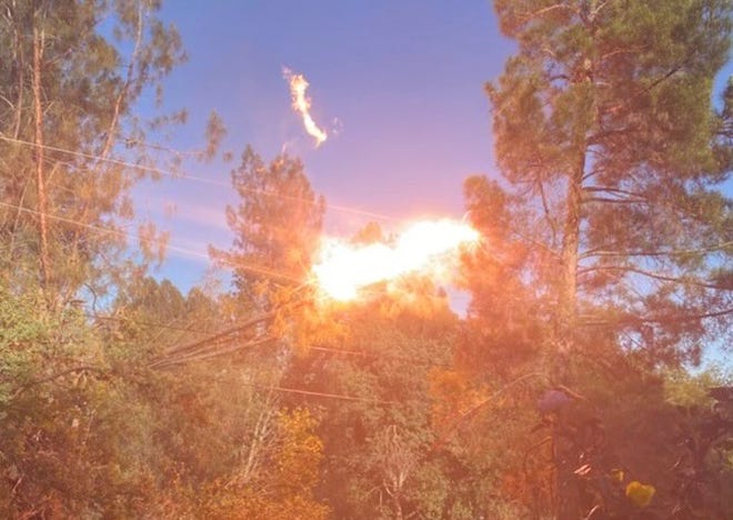 Heather Allen took a picture showing fire in the tree in front of her home west of Redding. The tree caught fire Wednesday night, May 4, 2022 when branches hit PG&E power lines.