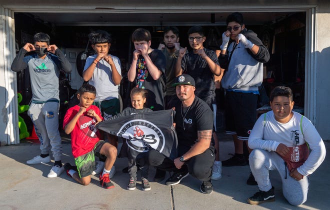 Rigo Avila, founder of AVILA Victory Boxing is photographed with some of her students after a training session outside the garage of Avila's parents' home in Greenfield on May 4th.