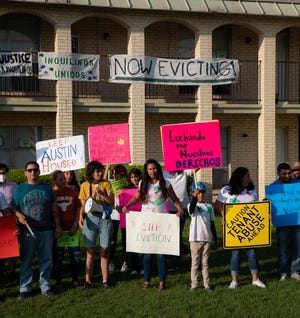 Residents and activists gather Friday in the courtyard of the Santa Fe Apartments for a protest in support of residents at the Clayton Lane and Santa Fe apartments, where residents say they are being pushed out of their homes.