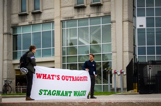 A sign supporting striking graduate workers is held outside Memorial Stadium during Indiana University's 193rd undergraduate commencement ceremony on Saturday, May 7, 2022.