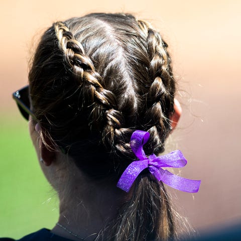 A Liberty softball player wears a purple ribbon in