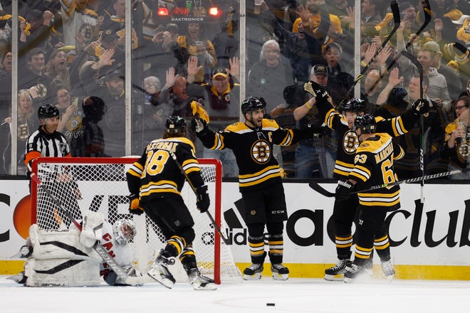 Bruins left wing Taylor Hall (second from left) celebrates his goal on Hurricanes goaltender Pyotr Kochetkov with Brad Marchand, right,  Patrice Bergeron and David Pastrnak, left, during the third period of Game 3 on Friday.