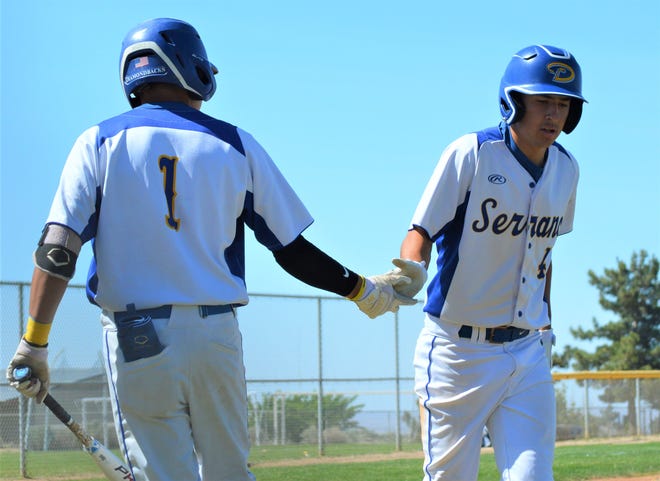 Serrano's Aiden Taylor, right, is greeted by  Jessie Naverrette after scoring a run in the first inning against Indio on Friday, May 6, 2022.