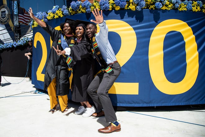 U-M graduates take photos before the Comeback Commencement for the Class of 2020 and 2021 at the Michigan Stadium in Ann Arbor on Saturday, May 7, 2022.