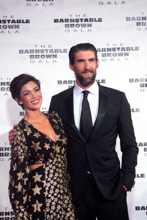 Model Nicole Johnson and her husband, Olympic swimmer Michael Phelps, pose for a photo on the red carpet at the Barnstable Brown Derby Eve Gala Friday night.