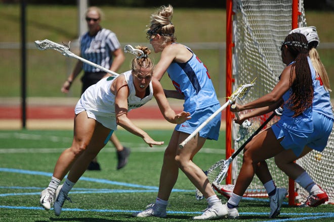 Brianna Samuels of Jacksonville University (left) was able to get a shot off and score against Liberty's Lizzy Ferguson (30) during the third quarter of Saturday's ASUN women's lacrosse championship at Rock Stadium.