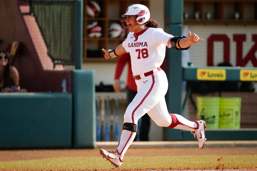 Jocelyn Alo celebrates with coach Oklahoma Sooners coach Patty Gasso after hitting a grand slam against Oklahoma State on May 7, 2022.