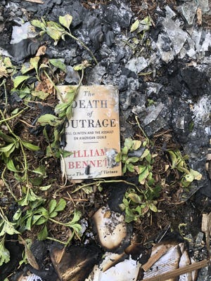 A book surrounded by charred pages and broken glass rests outside the Wisconsin Family Action office on Sunday, May 8, 2022 after an early morning fire. Police in Madison are investigating the incident as arson, and a spray-painted message on the outside of the building as a threat.
