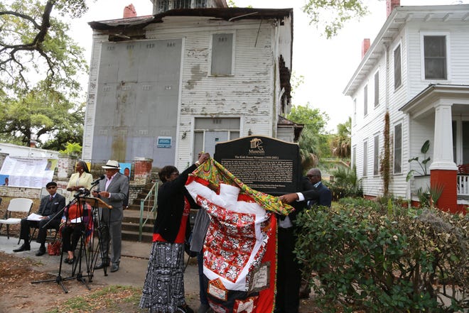 A historical marker is unveiled as Greg Kiah, nephew of Calvin and Virginia Kiah, reads the text from the marker Monday morning at the Kiah House Museum on West 36th Street.