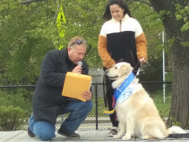 State Rep. Matt Muratore reads the citation given to Otis upon his win as America's Hometown Hound for 2022 as Otis' owner, Jolene Crawley, looks on.