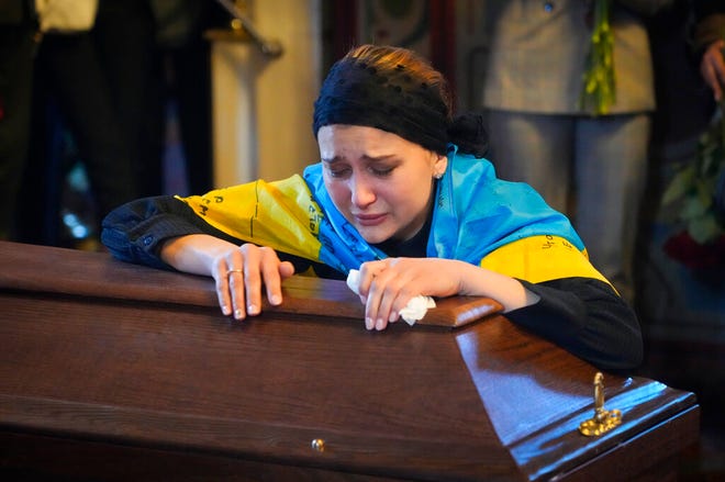Janda menangis di peti mati tentara sukarelawan Oleksandr Makhov, 36 jurnalis terkenal Ukraina, dibunuh oleh tentara Rusia, di Katedral St Michael di Kyiv, Ukraina, Senin, 9 Mei 2022. (AP Photo/Efrem Lukatsky)