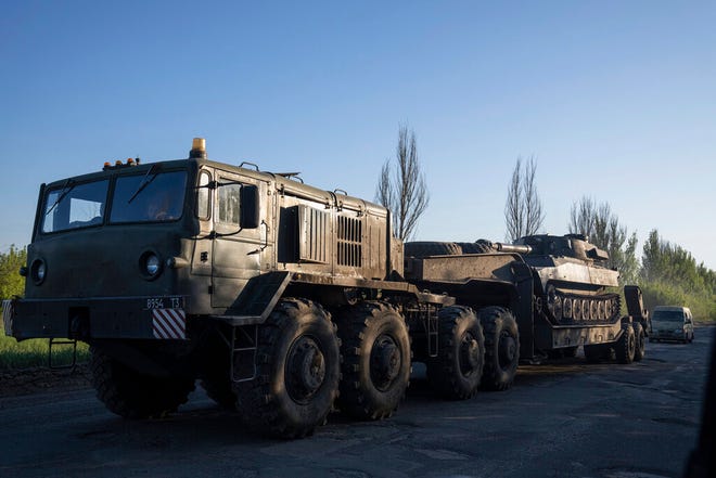 Sebuah truk militer mengangkut platform dengan artileri self-propelled Ukraina di wilayah Donetsk, Ukraina, Minggu, 8 Mei 2022.