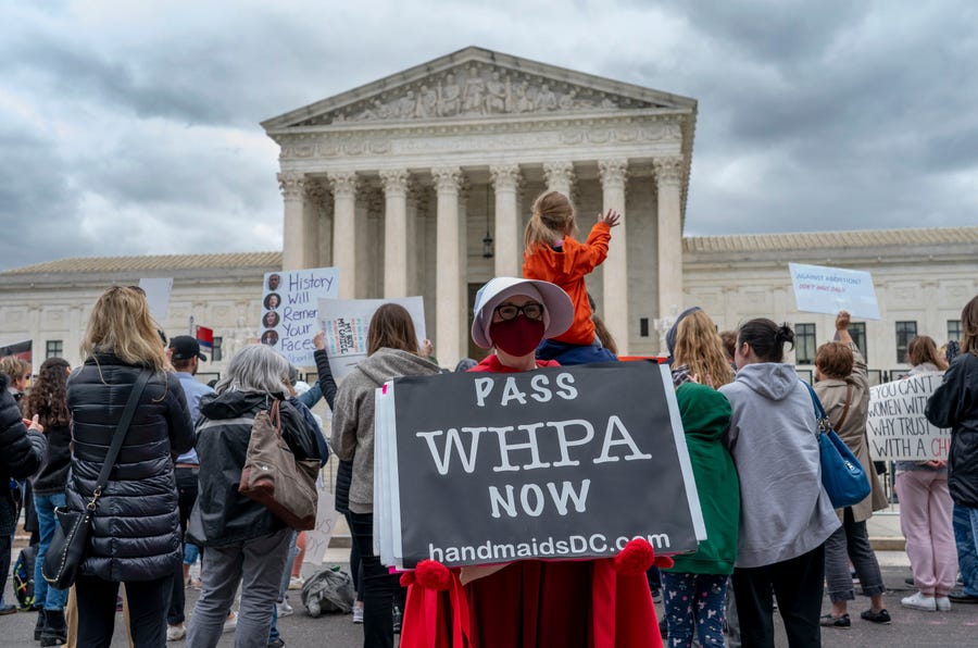 Abortion-rights protesters display placards during a demonstration outside of the U.S. Supreme Court, Sunday, May 8, 2022, in Washington.