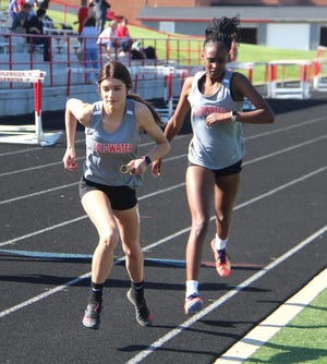 Coldwater's Chloe Vickers take the hand off from teammate Ta’Vaiyah Hughes during the 3200 meter relay Monday night