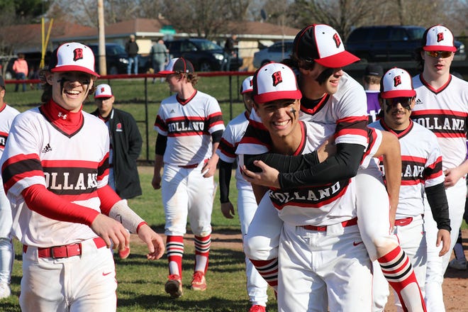 Members of the Holland HS baseball team celebrate a win over Wyoming