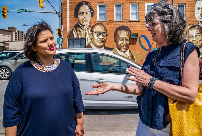 Irene Moore Davis, 50, of Windsor (left) is an educator and descendant of anti-slavery activist Mary Ann Shadd Cary (1823-1893). Davis stands with sculpture artist Donna Jean Mayne, 62, of Windsor, near a mural that features Mary Ann Shadd Cary.  Mayne sculpted the statue of Cary that will be unveiled on Thursday.