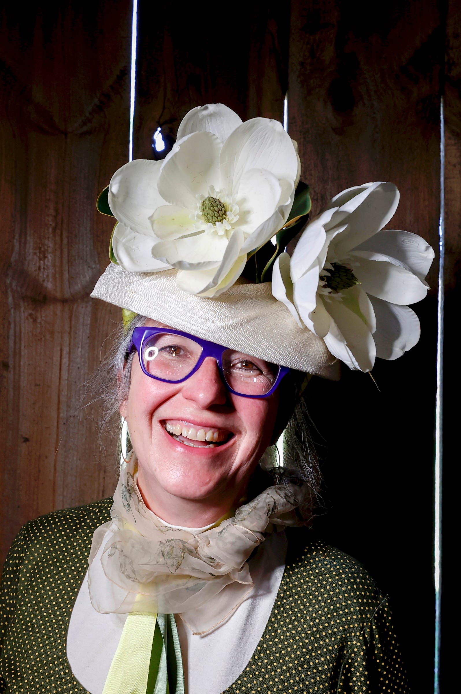 Helen Taylor, 61 of Okemos is all smiles showing off her  Kentucky Derby to the fifth annual Hats & Horses Kentucky Derby Party at Iron Fish Distillery in Thompsonville, Michigan on Saturday, May 7, 2022.The distillery on the west side of the state has their own derby horse race that each year raises money for charity.This year a crowd of over 300 cheered as four retired race horses sprinted down the dirt road in front of the distillery.